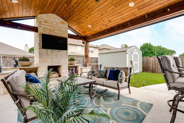 1617 Mack Ln, Little Elm, TX 75068 - view of patio with an outdoor living space with a fireplace, a fenced backyard, a storage unit, and an outdoor structure