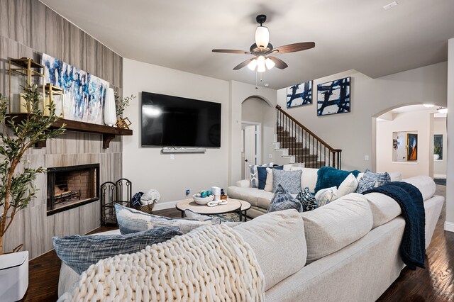 1617 Mack Ln, Little Elm, TX 75068 - living room featuring arched walkways, ceiling fan, stairway, dark wood-style flooring, and a fireplace