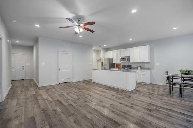 2801 17th St, Fort Worth, TX 76106 - kitchen with white cabinets, appliances with stainless steel finishes, a ceiling fan, recessed lighting, and wood finished floors