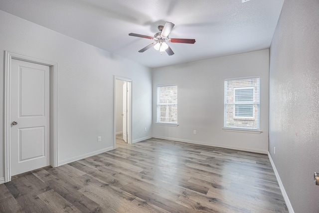 2801 17th St, Fort Worth, TX 76106 - unfurnished bedroom with baseboards, a ceiling fan, wood finished floors, and multiple windows