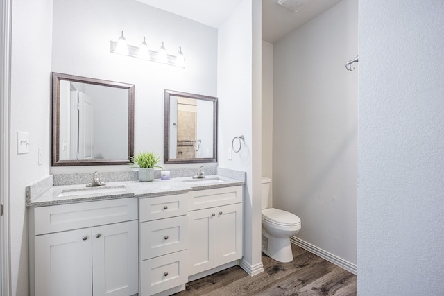 2801 17th St, Fort Worth, TX 76106 - bathroom featuring double vanity, a sink, wood finished floors, and toilet