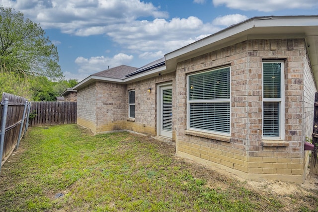 2801 17th St, Fort Worth, TX 76106 - view of property exterior featuring a fenced backyard, a lawn, roof with shingles, and brick siding