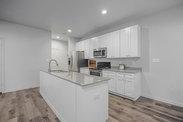 2801 17th St, Fort Worth, TX 76106 - kitchen featuring visible vents, wood finished floors, white cabinetry, a sink, and appliances with stainless steel finishes