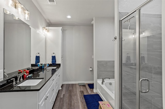 141 Walnut St, Paradise, TX 76073 - full bathroom featuring double vanity, wood finished floors, a bath, a stall shower, and recessed lighting