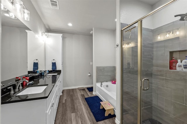 141 Walnut St, Paradise, TX 76073 - full bath featuring double vanity, a garden tub, wood finished floors, a stall shower, and recessed lighting
