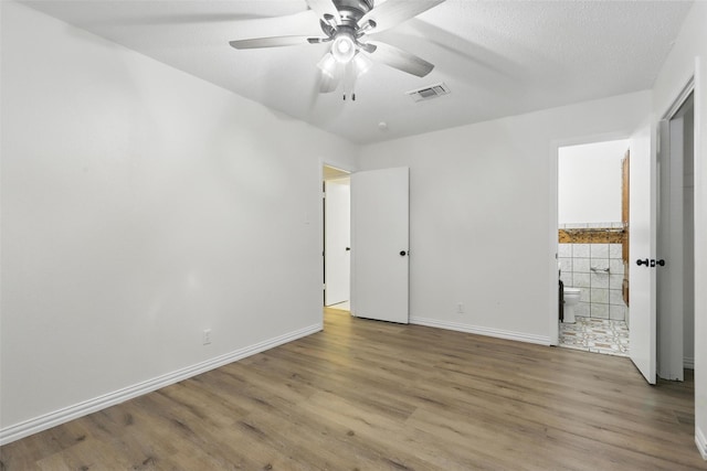1038 Oak Hurst Dr, Grapevine, TX 76051 - unfurnished bedroom with wood finished floors, baseboards, ensuite bath, and a ceiling fan
