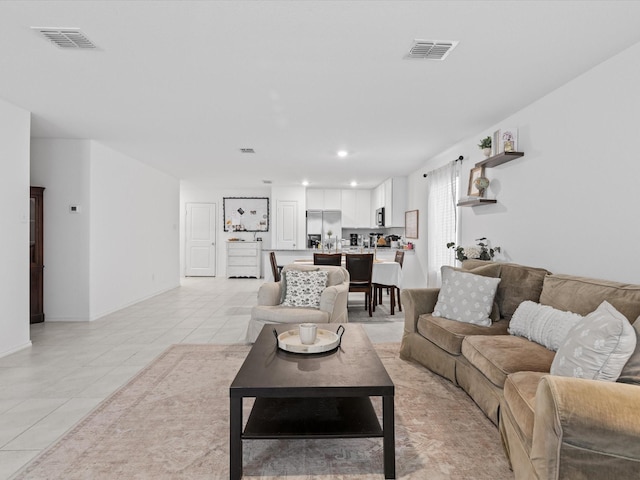 living room with light tile patterned flooring, baseboards, visible vents, and recessed lighting