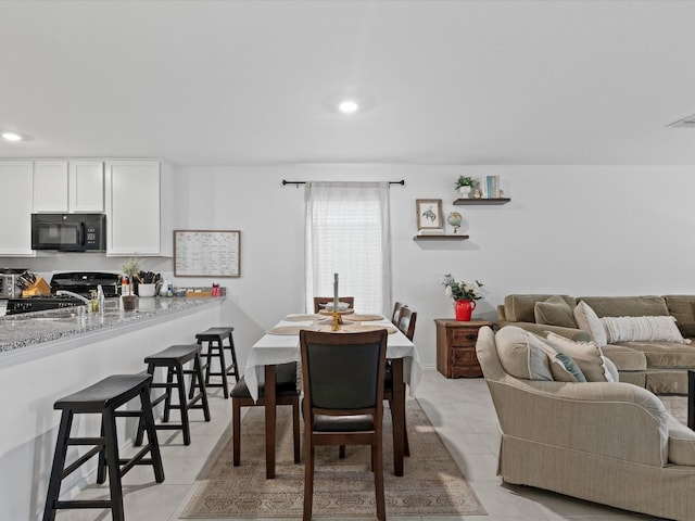dining area with light tile patterned floors and recessed lighting