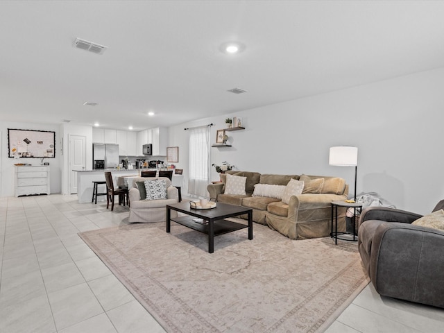 living room featuring light tile patterned floors, recessed lighting, and visible vents