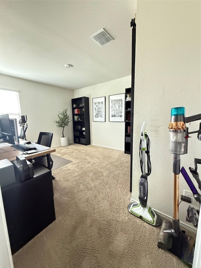 office with carpet floors, a textured ceiling, visible vents, and baseboards