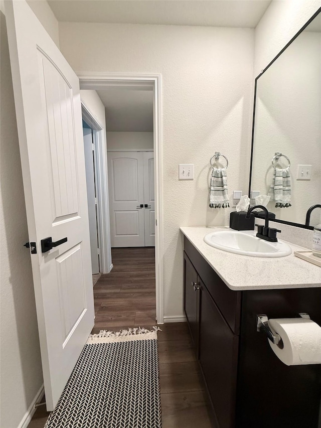 bathroom with vanity, baseboards, and wood finished floors
