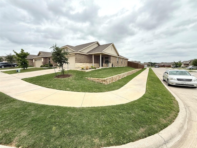 view of side of property with brick siding, roof with shingles, a yard, and driveway
