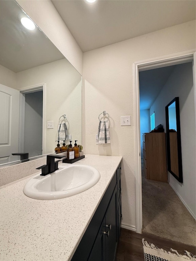 bathroom featuring vanity, baseboards, and wood finished floors