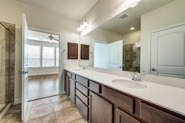 1130 Pasatiempo Dr, Frisco, TX 75036 - bathroom featuring double vanity, a shower stall, a ceiling fan, baseboards, and tile patterned floors