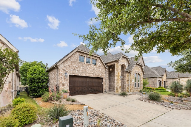 5924 Heron Bay Ln, Mckinney, TX 75070 - french provincial home featuring concrete driveway, brick siding, fence, and roof with shingles