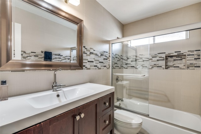 full bath featuring backsplash, tile walls, bath / shower combo with glass door, vanity, and toilet