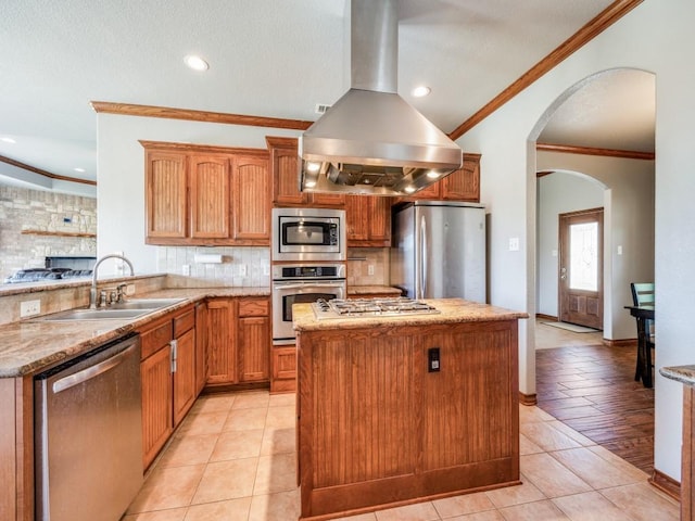 kitchen featuring crown molding, decorative backsplash, island exhaust hood, a sink, and appliances with stainless steel finishes