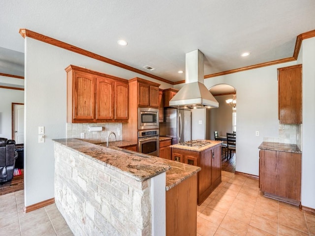 kitchen with stainless steel appliances, tasteful backsplash, a kitchen island, and island range hood
