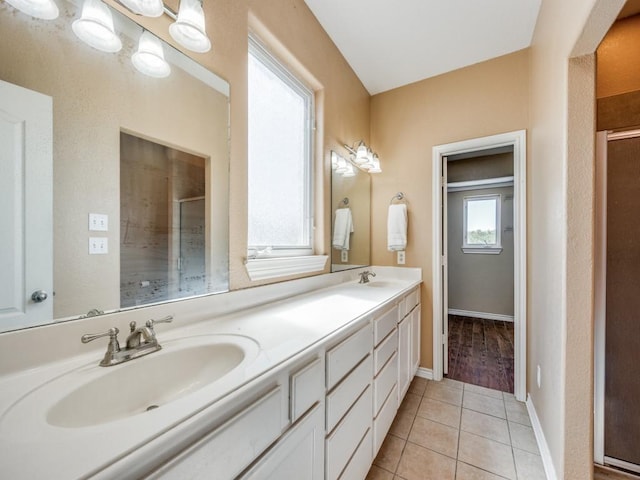 full bathroom featuring double vanity, a sink, tile patterned floors, and a shower stall
