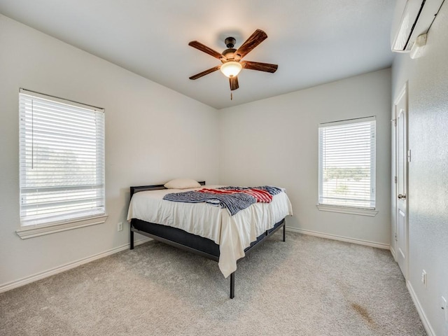 bedroom featuring carpet flooring, a ceiling fan, baseboards, and a wall mounted AC