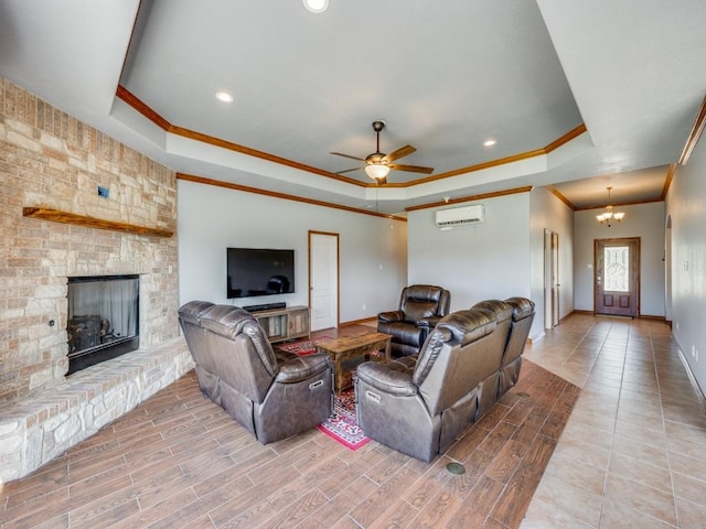 living area with crown molding, baseboards, a raised ceiling, and a wall unit AC