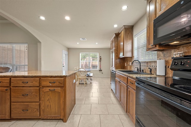 kitchen with visible vents, brown cabinets, a sink, black appliances, and recessed lighting