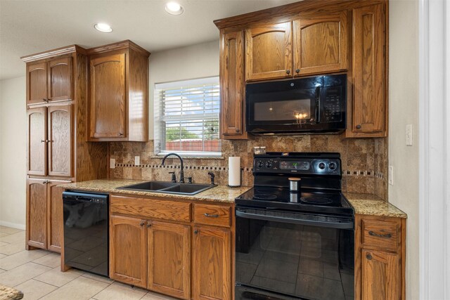 kitchen with recessed lighting, a sink, backsplash, light tile patterned floors, and black appliances