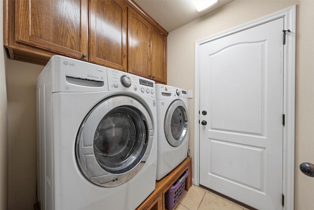 clothes washing area featuring cabinet space, independent washer and dryer, and light tile patterned floors