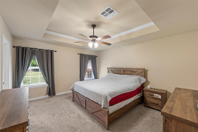 bedroom with visible vents, baseboards, ceiling fan, light colored carpet, and a tray ceiling