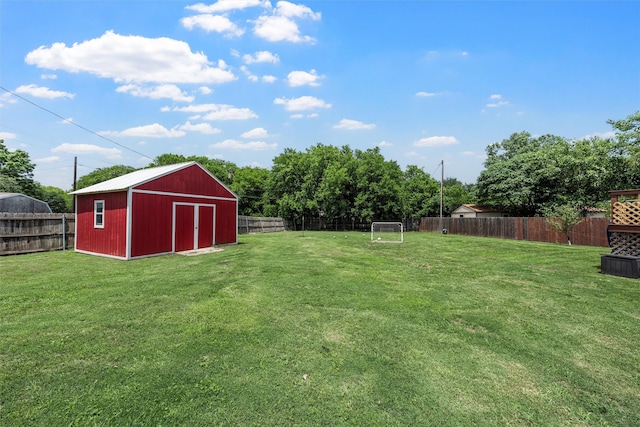 view of yard featuring an outdoor structure, a fenced backyard, and a shed