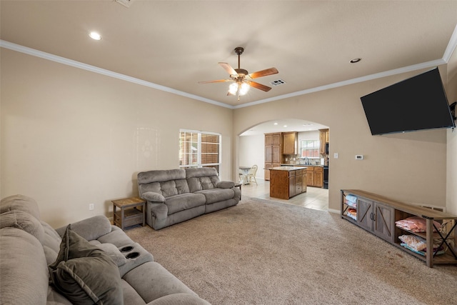 living area featuring arched walkways, ceiling fan, visible vents, and a healthy amount of sunlight