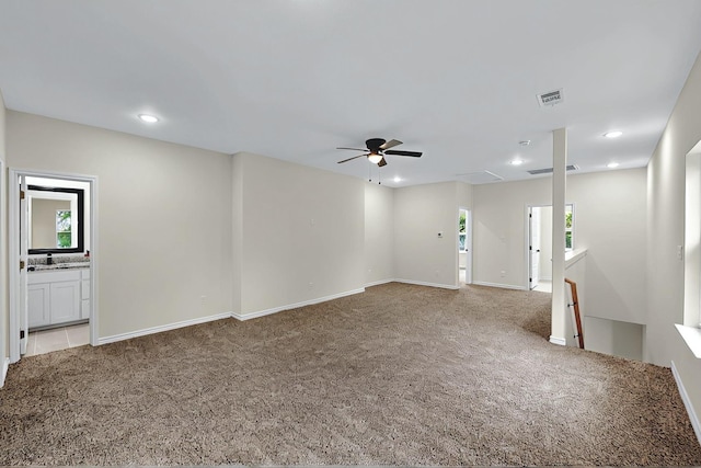 unfurnished living room featuring carpet floors, a ceiling fan, and plenty of natural light