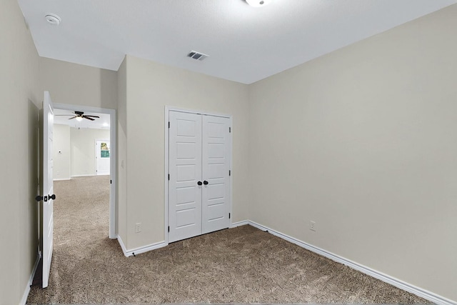 unfurnished bedroom with carpet flooring, baseboards, visible vents, and a closet