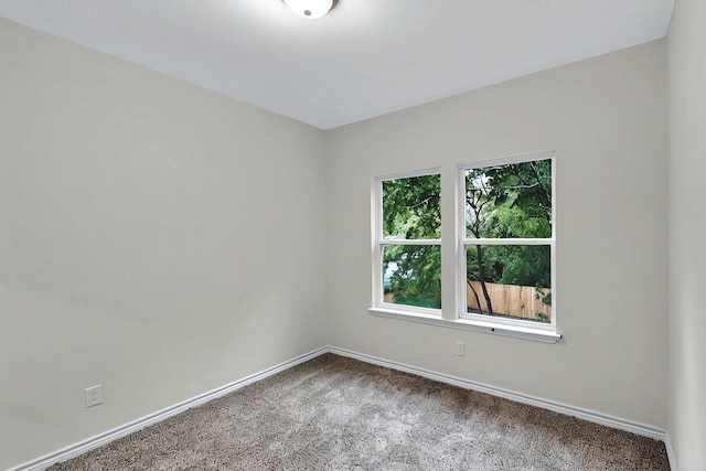 spare room with baseboards and carpet
