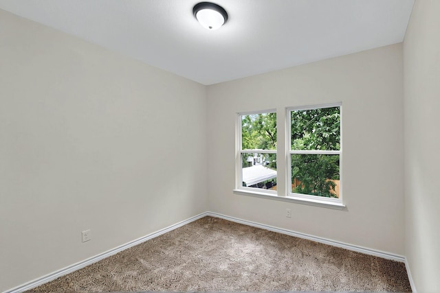 carpeted empty room with baseboards