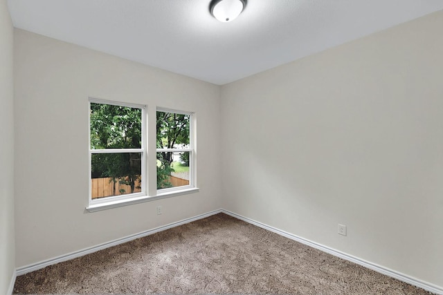 empty room featuring carpet floors and baseboards