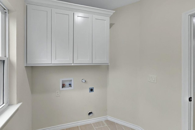 clothes washing area with cabinet space, hookup for a washing machine, gas dryer hookup, baseboards, and hookup for an electric dryer