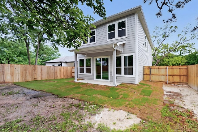 rear view of house with a lawn and a fenced backyard