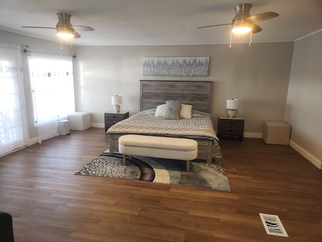 bedroom with baseboards, ceiling fan, wood finished floors, and visible vents