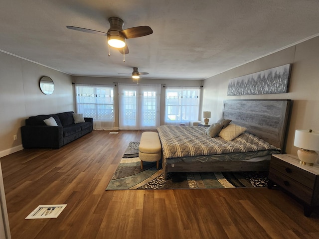 bedroom featuring multiple windows, a ceiling fan, wood finished floors, and visible vents