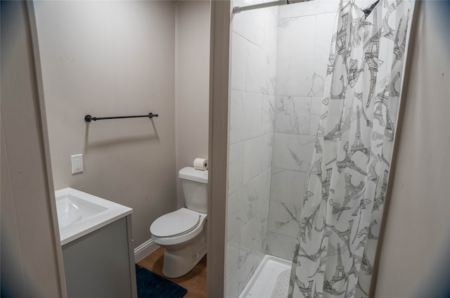 bathroom with vanity, wood finished floors, toilet, and a shower stall