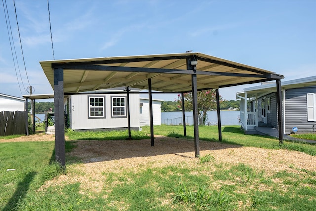exterior space featuring fence, a carport, and a water view