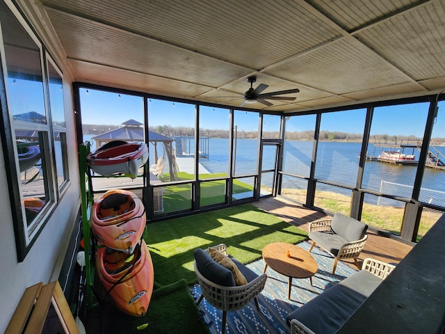 sunroom / solarium with a water view, a ceiling fan, and a healthy amount of sunlight