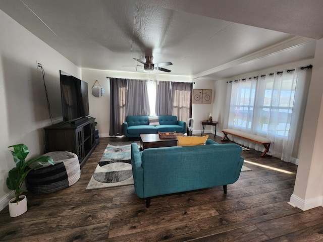 living area with baseboards, ceiling fan, and wood-type flooring