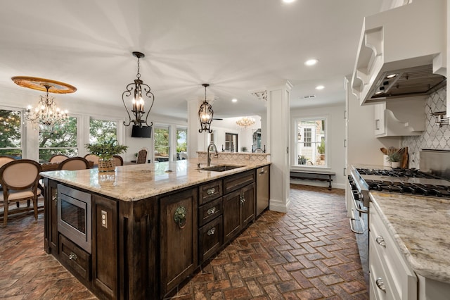 8121 Cahoba Dr, Fort Worth, TX 76135 - kitchen featuring stainless steel appliances, a chandelier, a sink, wall chimney exhaust hood, and recessed lighting
