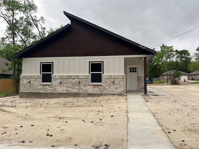 exterior space with fence and brick siding