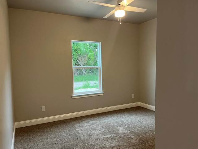 carpeted empty room featuring baseboards and a ceiling fan