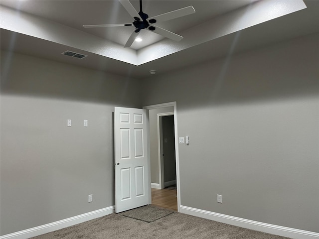 carpeted empty room featuring baseboards, ceiling fan, and visible vents