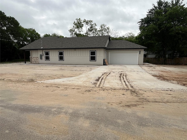 single story home featuring fence, driveway, roof with shingles, and a garage