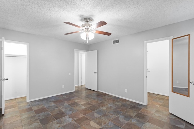 4211 Fairway Dr, Granbury, TX 76049 - unfurnished bedroom with a spacious closet, a closet, stone finish floors, a textured ceiling, and baseboards